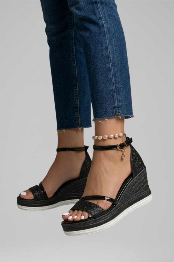Black cushioned orthopedic sandals worn with jeans