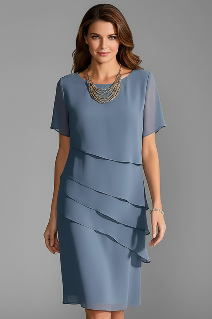 Woman wearing a blue layered short sleeve dress, front view