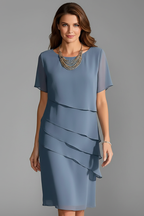 Woman wearing a blue layered short sleeve dress, front view