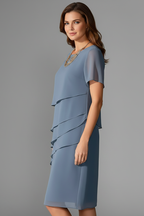 Woman wearing a blue layered short sleeve dress, three-quarter side view