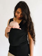 Woman wearing the Black CuddleNest kangaroo shirt with baby supported