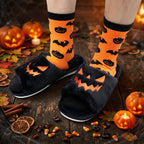Black Halloween pumpkin slippers worn with orange pumpkin socks on a rustic Halloween table