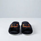 Pair of black plush Halloween slippers with orange jack-o'-lantern face