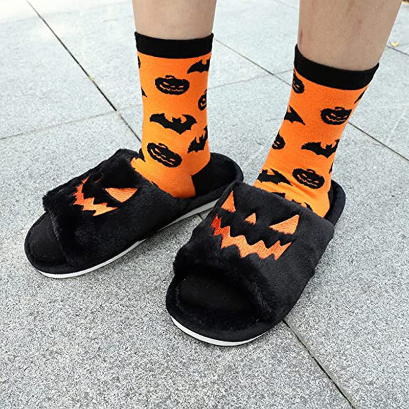 Black plush pumpkin slippers worn outdoors with orange Halloween socks
