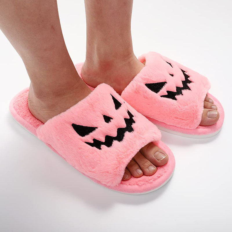 Pink plush pumpkin slippers worn on feet