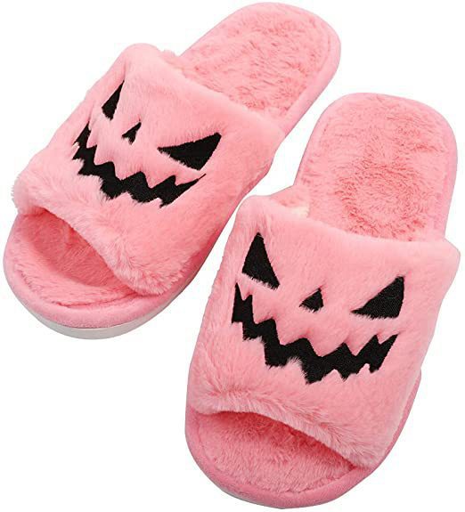 Pair of pink plush Halloween slippers with black jack-o'-lantern face