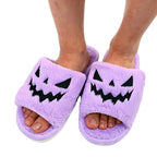 Close-up of purple plush pumpkin slippers worn on feet