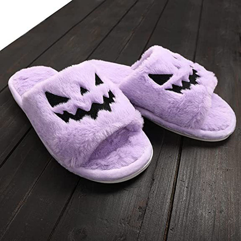 Purple plush Halloween slippers on a dark wooden floor