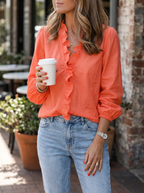 Woman wearing frilly ruffle top in orange with jeans